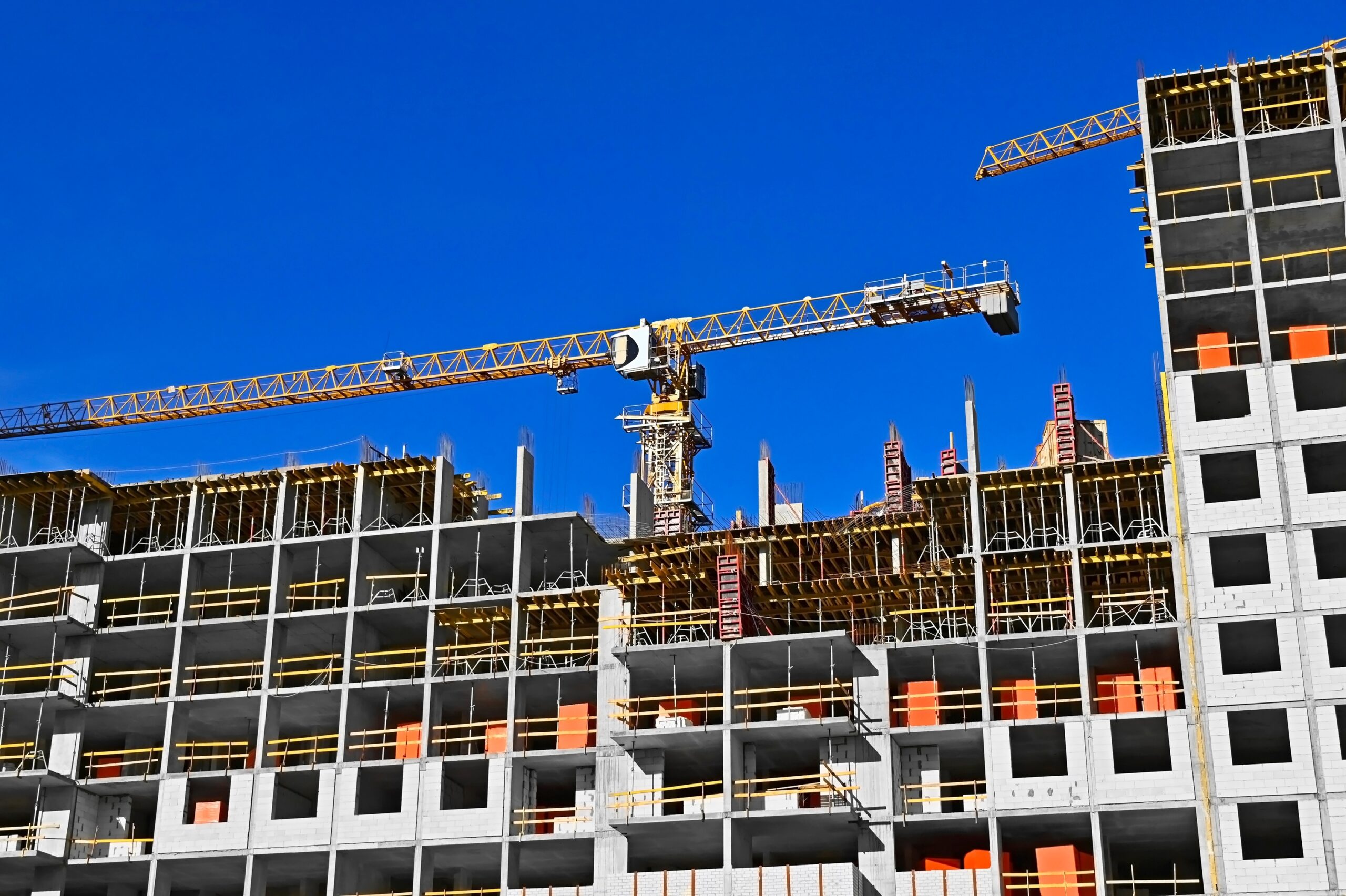 multistory,construction,site,with,crane,and,blue,sky