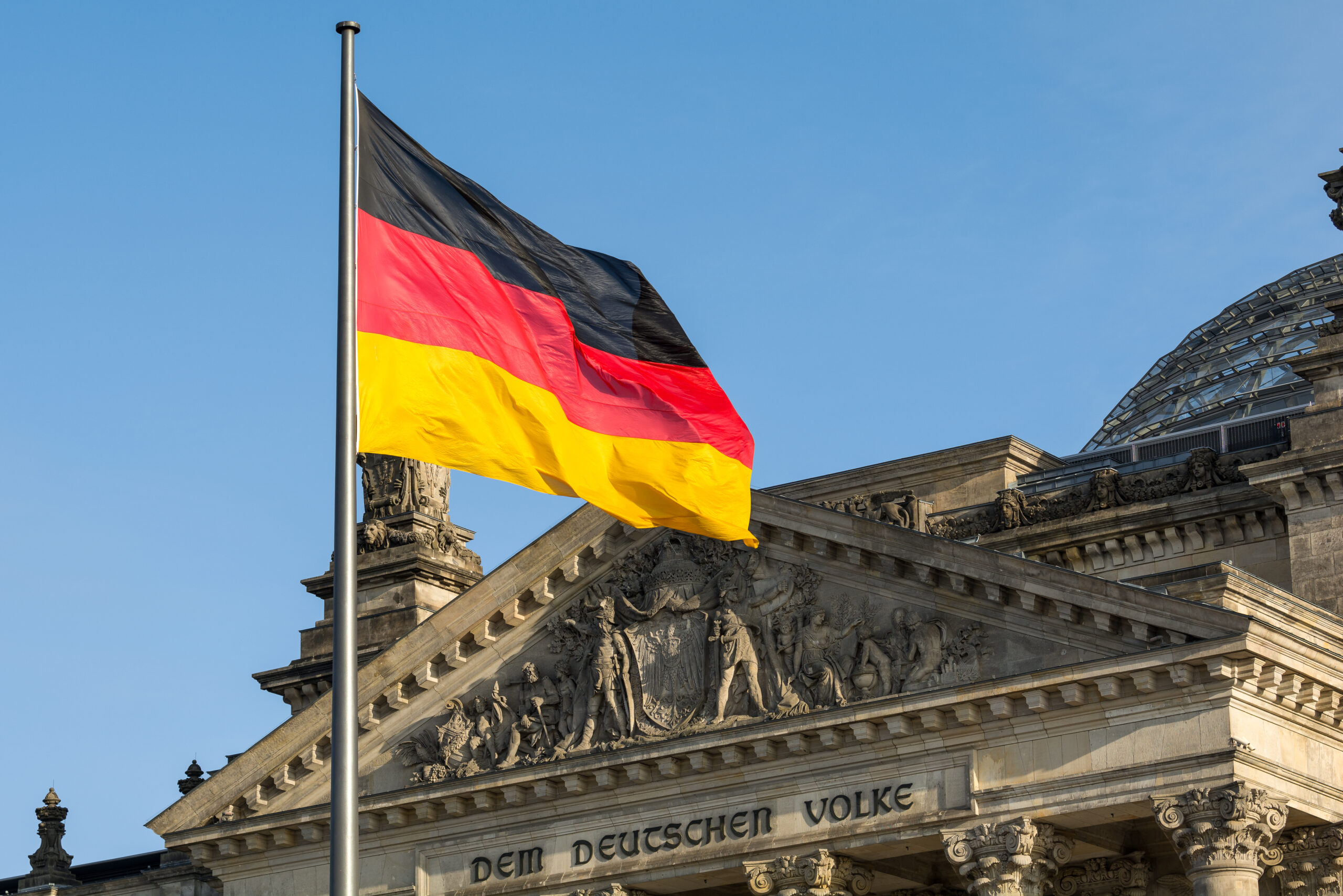 facade,of,the,german,parliament,with,the,german,flag,fluttering.