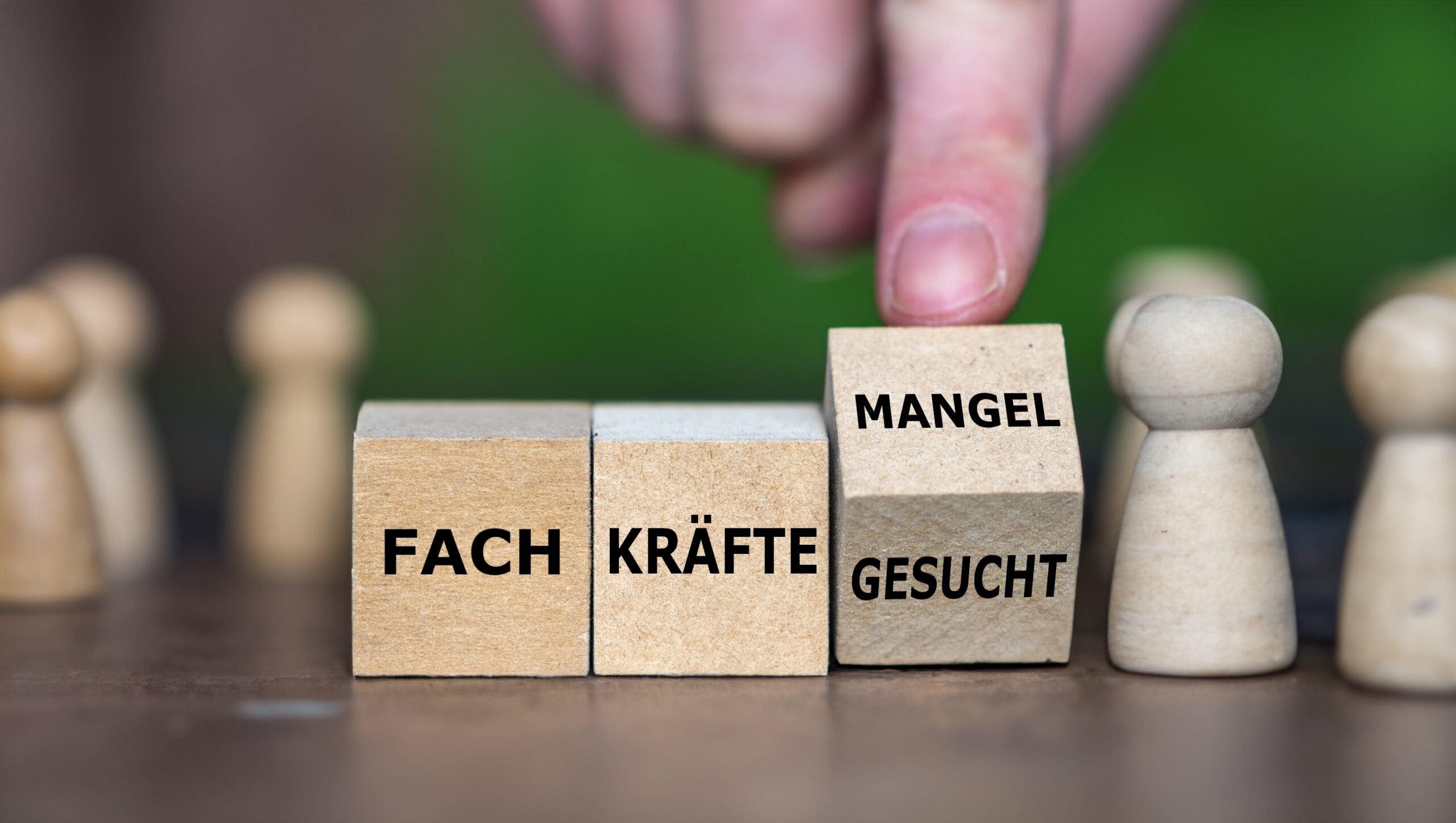 hand,turns,wooden,cube,and,changes,the,german,expression,'fachkraefte